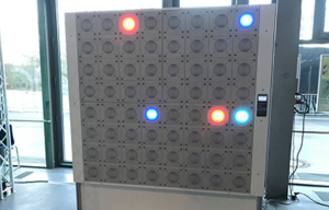 Große, beleuchtete Matrixwand mit verschiedenfarbigen Lichtern, stehend in einem modernen Innenraum.